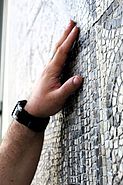 tastende Hände auf eines mosaikbezierten "Teppichs"