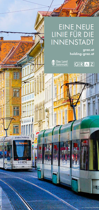 Bildtext: Gebäude mit Gehsteig, in der Mitte Straßenbahnschiene und  Fahrradweg .