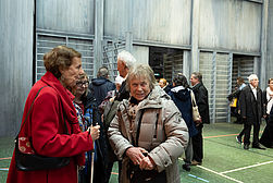 Frau Ann Linhart-Eicher, eine Mitarbeiterin des BSVSt im Ruhestand,mit zwei unserer Mitglieder auf der Bühne, deren Boden dem eines Spielfeldes einer Mehrzwecksporthalle gleicht.