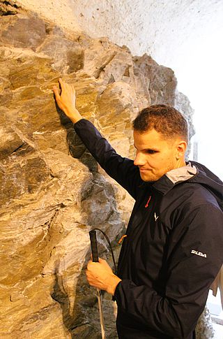 Bildtext: Ertasten der Schieferwand, die vom Empfang im Schloss Trautenfels in die Ausstellungsräume führt.